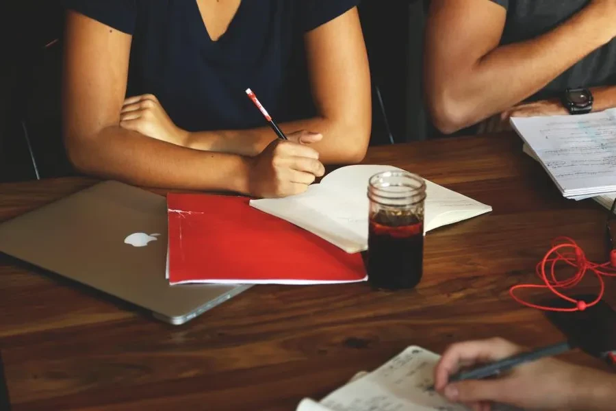 Sesión de trabajo alrededor de una mesa, con documentos y notas