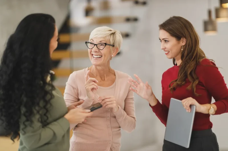 Dos compañeras conversan en la oficina