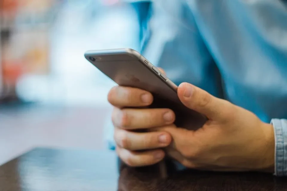 Una persona consulta su móvil, como un candidato que busca información sobre una empresa